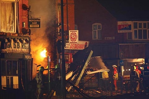 Members of the emergency services work at the site of an explosion which destroyed a convenience store