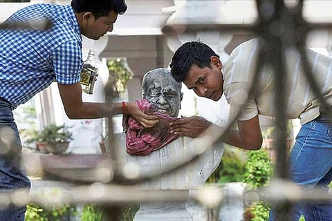 A group of people clean the bust of Jana Sangh?s founder Dr Syama Prasad Mukherjee