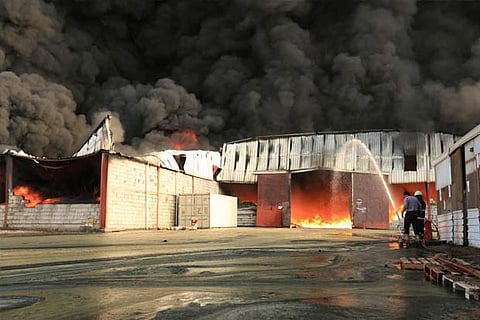 Firefighters try to extinguish a fire engulfing warehouse of the World Food Programme in Hodeida