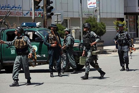 Afghan security personnel inspect at the site of suicide attack