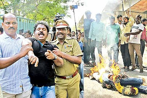 Film director Gowthaman being taken away by police after (r) he burned an effigy of Anil Agarwal