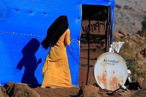 A Syrian woman is seen near a tent in a refugee camp in Marjayoun, Lebanon