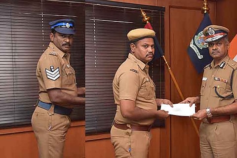 Head constable B Murugan and Home Guard volunteer M Sam Jeyaraj receive rewards from AK Viswanathan