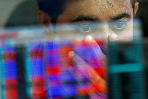 A broker reacts while trading at his computer terminal at a stock brokerage firm in Mumbai