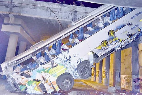 The mangled remains of the bus rest in a slanting position after it fell of a bridge near Tirupur on Sunday