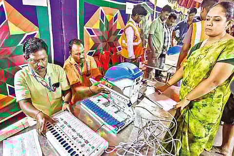 Poll officials fix symbols and candidate names on the electronic voting machines (EVM) in Chennai on Thursday
