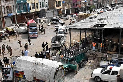 Rescue workers and army soldiers gather at the site of a blast at a vegetable market in Quetta