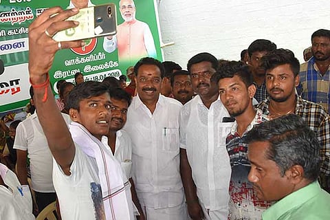 An AIADMK worker takes a selfie with Transport Minister Vijayabaskar, in Karur on Wednesday