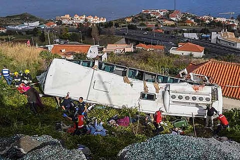 Rescue officials attend the scene after a tour bus crashed in Canico on Portugal's Madeira Island