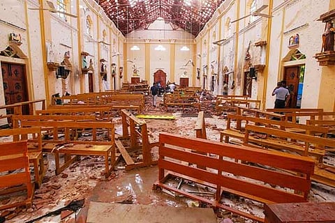 Crime scene officials inspect the site of a bomb blast inside St Sebastian's Church in Sri Lanka