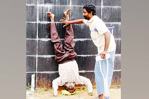 Perambalur village resident R Ponnusamy walking upside down towards the Collectorate on Monday