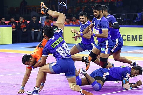 Haryana Steelers defenders try to pin down U Mumba raider Sandeep Narwal (in orange)