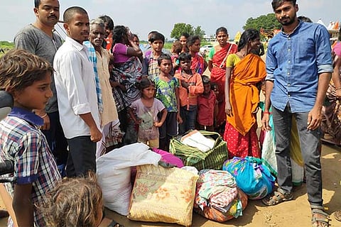 Youngsters distributing the old clothes collected from donors to a group of nomads in Vellore