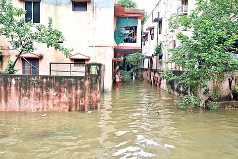 A girl stands in knee-deep water at a colony in Korattur on Sunday