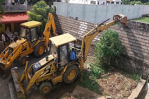 Demolition of some weak compound walls in the area under way at Nadur village in Mettupalayam near Coimbatore