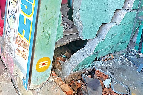 The cracks on the walls of a mechanic?s shop in New Washermanpet