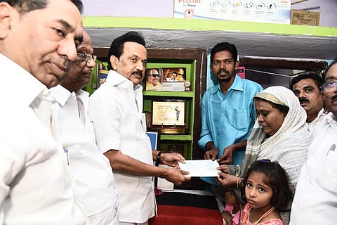 DMK chief MK Stalin providing Rs 5 lakh to kin of deceased partyman Saleem in Madurai on Sunday