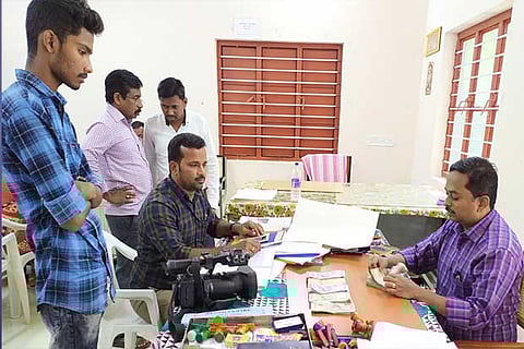 An election officer counts the money (Inset) seized from the independent candidate in Erode district