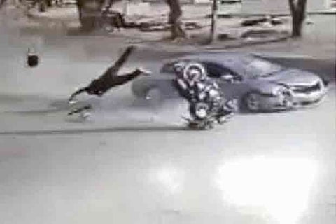 Video grab shows the biker tossed in the air as the car rams the two-wheeler