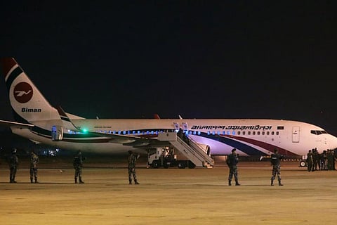 Security personnel stand guard outside of the hijacked aircraft of the Biman Bangladesh Airlines