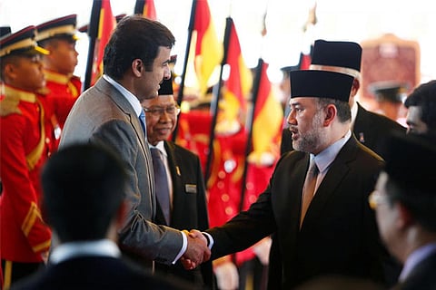 Qatar's Emir Sheikh Tamim bin Hamad al-Thani (L) shakes hand with Malaysia's King Muhammad V