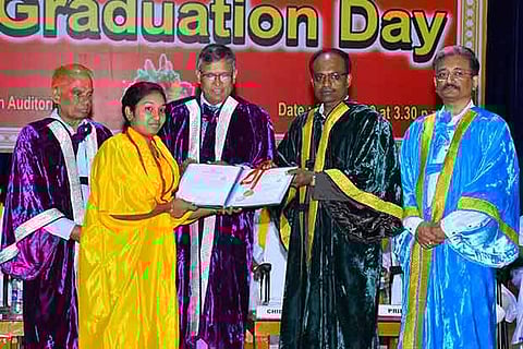 The Managing Director of Accenture Sathappan Narayanan presents a certificate and a medal to a graduate