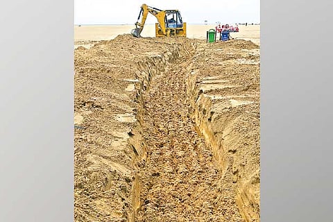 Civic body digging trenches on Marina beach on Tuesday to prevent water stagnation after rain