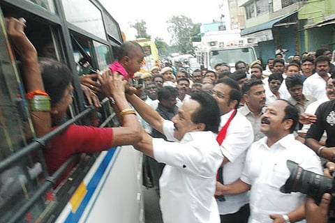 DMK president MK Stalin clasps a child while campaigning for party candidate Kathir Anand in  Vellore