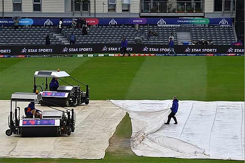 Groundsmen cover the pitch as rain prevented play in the World Cup