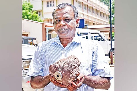 K Lakshmi Narayan holds the meteorite with a magnet attached to it