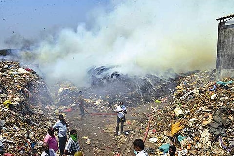 Fumes emerge from the fire which broke out in the  dump yard in Pollachi on Friday