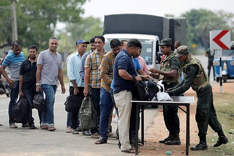 Sri Lankan army personnel search people and their bags at a check point in the village of Kattankudy