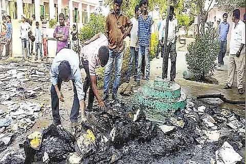 Students searching for their certificates among the burnt pile