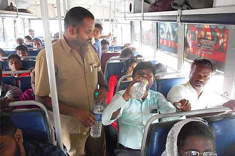 Thirugnanam distributing water on the bus