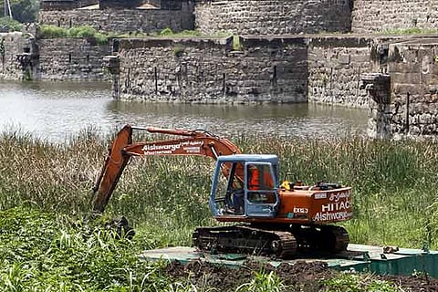 An earth-moving machinery mounted on a float involves in dredging operation at the Vellore fort (File photo)