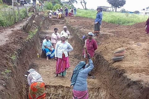 Workers dig a trench in the elephant corridor