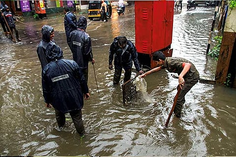 Thane: Municipality workers unclog a drain following heavy monsoon rains, in Thane
