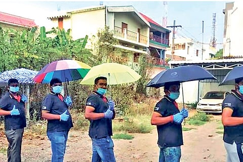 Volunteers demostrating the use of umbrellas in social distancing