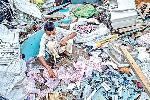 A man in New Delhi looks through garbage for valuable items to sell