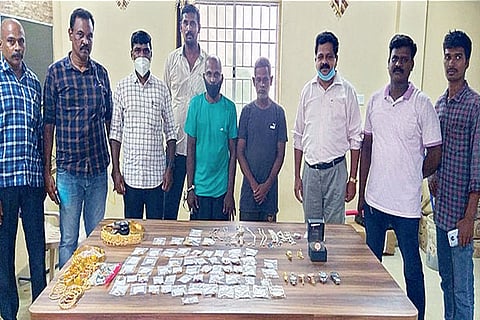 Seized valuables and arrested burglars with police