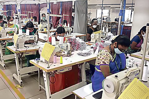 Workers stitching masks and other personal protection equipment at a knitwear unit in Tirupur