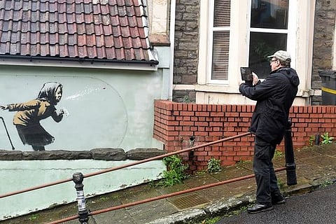 Banksy mural of sneezing woman appears on England's steepest street