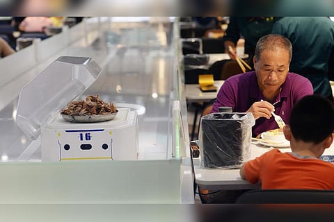 A man waiting for his food which will be delivered by a robot (File photo: AFP)