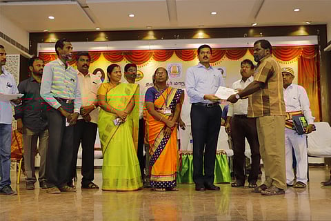 Collector Govindarao handing over the reward to a sanitary staffer in Thanjavur on Friday
