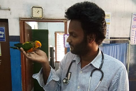 Veterinarian Ravi Sankar with the bird after removing plastic tube successfully from its throat on Saturday
