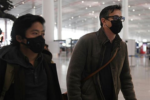 Wall Street Journal reporters Philip Wen (left) and Josh Chin on their way out of China (Image: AFP)