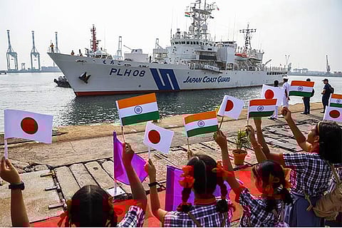 Children hold up flags of India, Japan, while welcoming the Japan Coast Guard vessel Echigo,
