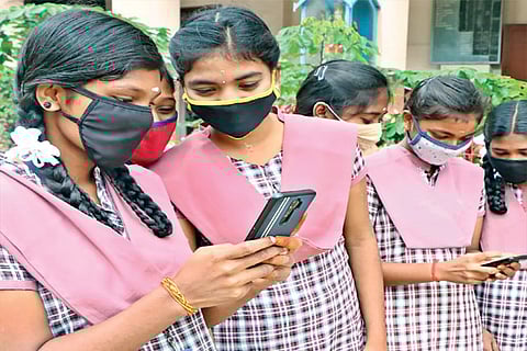 Students check their results on mobile phones at a school in Coimbatore