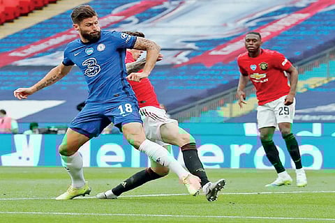 Chelsea forward Olivier Giroud vies for the ball with a Manchester United player
