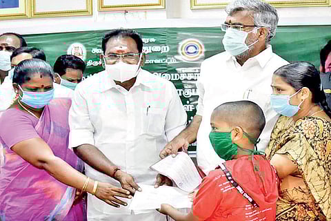 Minister Sellur Raju distributes relief to family members of VAO Kumar, who recently died